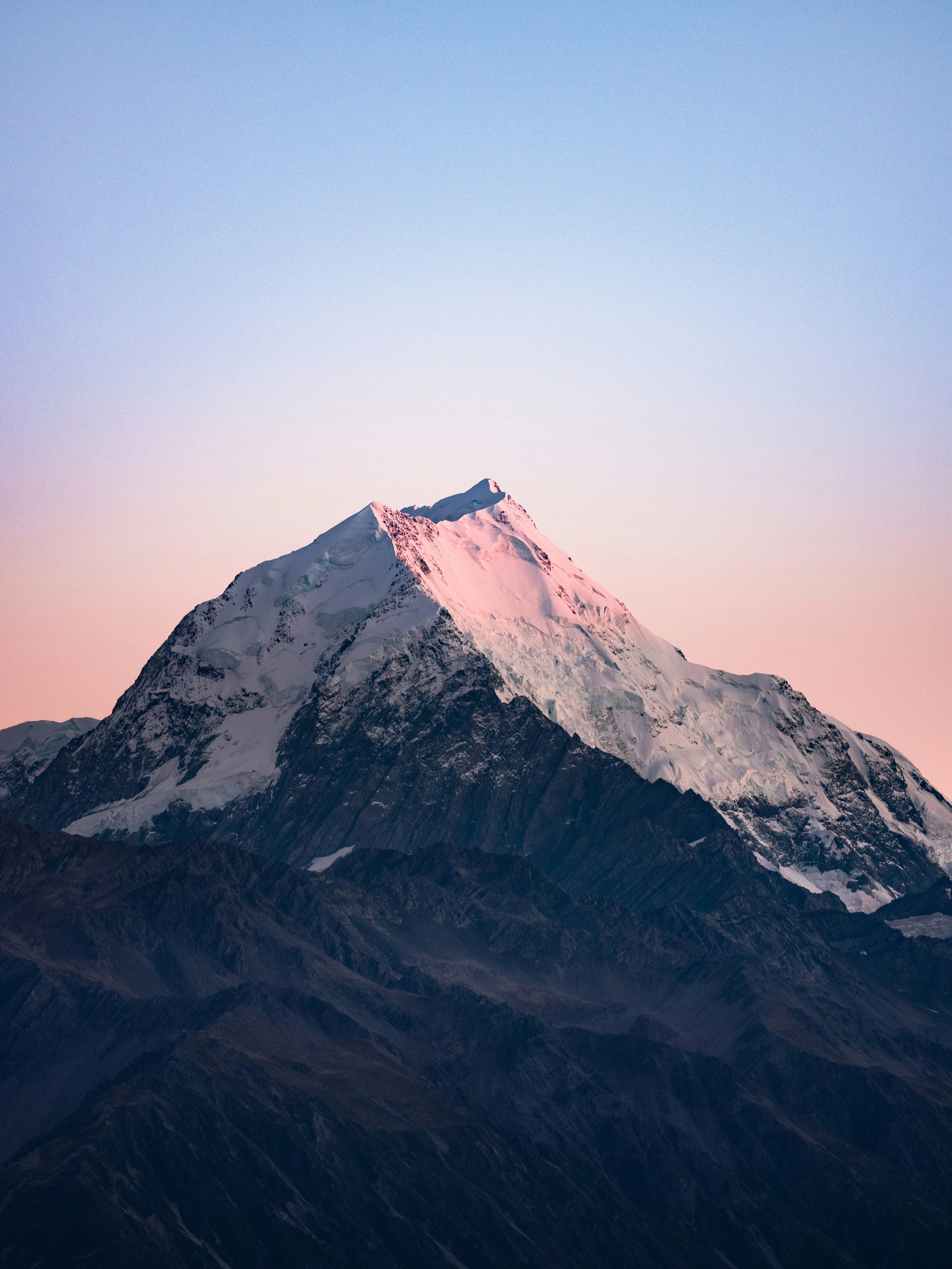 Image of a mountain top with a pink sky